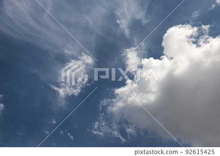 White fluffy clouds in a serene blue sky White fluffy clouds in a serene blue sky 92615425