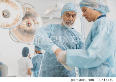 Team of surgeons in the operating room preparing for surgery Team of surgeons in the operating room preparing for surgery 92615430