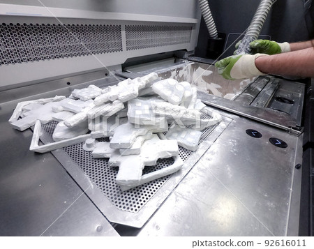 Engineer or artist designer printing 3D parts and shaping models from dust 3D print. Sculpting, creating, making. New 3D printing technologies. Multi Jet Fusion. Advanced additive technology in use. 92616011