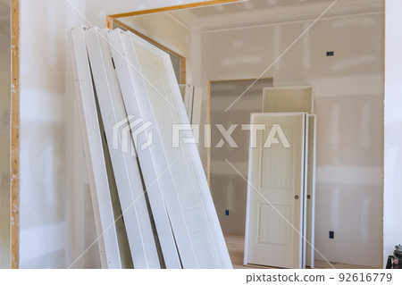 The installation of white stacker doors in the interior of a new home is being prepared 92616779