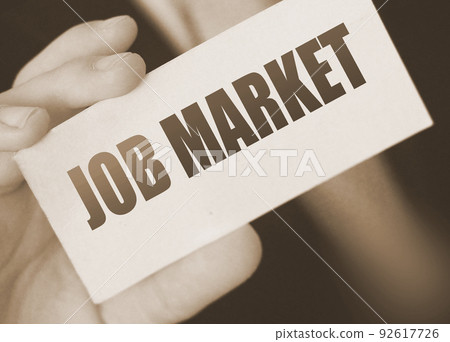 Businessman holds a card with the text Job Market. Business concept 92617726