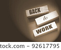 Coronavirus concept showing wooden blocks on a dark grey background reading Back To Work 92617795