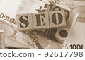 SEO - wooden blocks with letters, search engine optimization SEO concept, top view on 100 euro banknotes background 92617798