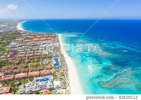 Bounty and pristine sandy shore with coconut palm trees, caribbean sea washes tropical coast. Arenda Gorda beach. Dominican Republic. Aerial view Bounty and pristine sandy shore with coconut palm trees, caribbean sea washes tropical coast. Arenda Gorda beach. Dominican Republic. Aerial view 92619112