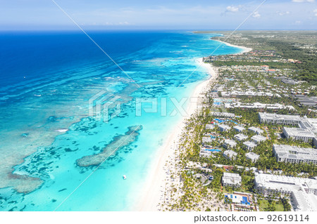 Bounty and pristine sandy shore with coconut palm trees, caribbean sea washes tropical coast. Arenda Gorda beach. Dominican Republic. Aerial view 92619114