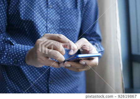 Close up of young man hand using smart phone. 92619867