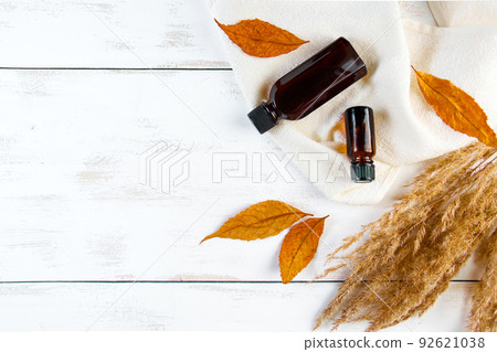 Set of bottles with essence oil or cosmetic serum on a white background. Autumn skin care concept. Eco-friendly cosmetics and yellow fallen leaves. Copy space. Set of bottles with essence oil or cosmetic serum on a white background. Autumn skin care concept. Eco-friendly cosmetics and yellow fallen leaves. Copy space. 92621038