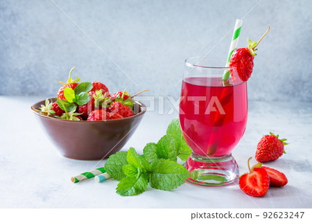 Refreshing summer drink strawberry juice, fresh strawberries and mint on a gray stone or slate background. Healthy breakfast on the kitchen table. 92623247