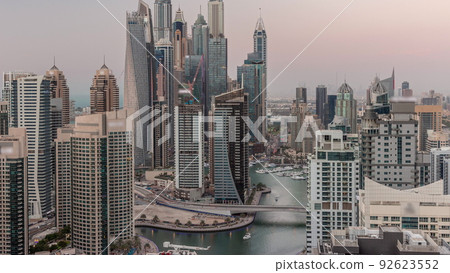 View of various skyscrapers in tallest recidential block in Dubai Marina aerial day to night timelapse View of various skyscrapers in tallest recidential block in Dubai Marina aerial day to night timelapse 92623552