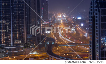 Busy Sheikh Zayed Road aerial night to day timelapse, metro railway and modern skyscrapers around in luxury Dubai city. Busy Sheikh Zayed Road aerial night to day timelapse, metro railway and modern skyscrapers around in luxury Dubai city. 92623598