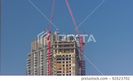 Two cranes working on constraction site works of new skyscraper timelapse 92623702