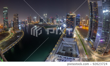 Cityscape panorama of skyscrapers in Dubai Business Bay with water canal aerial all night timelapse 92623724