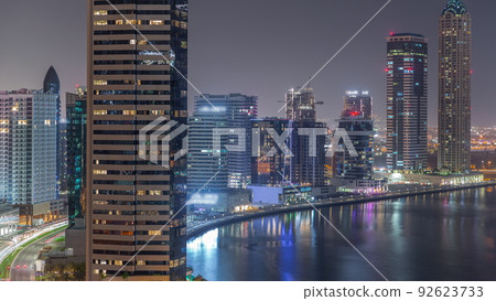 Cityscape of skyscrapers in Dubai Business Bay with water canal aerial night timelapse 92623733