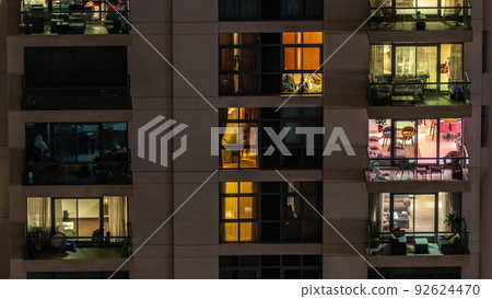Windows of apartment building at night timelapse, the light from illuminated rooms of houses 92624470