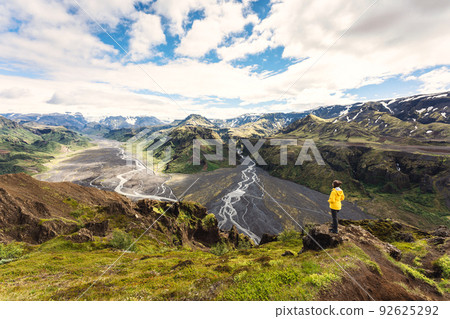 Valahnukur viewpoint with female hiker standing on peak and krossa river flowing through in icelandic highlands at Thorsmork, Iceland Valahnukur viewpoint with female hiker standing on peak and krossa river flowing through in icelandic highlands at Thorsmork, Iceland 92625292
