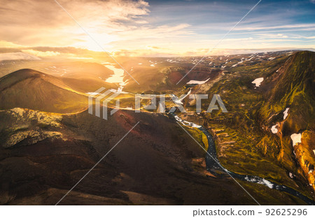 Aerial view of sunset over mysterious volcanic crater and glacier stretches through the central highlands of iceland on summer Aerial view of sunset over mysterious volcanic crater and glacier stretches through the central highlands of iceland on summer 92625296