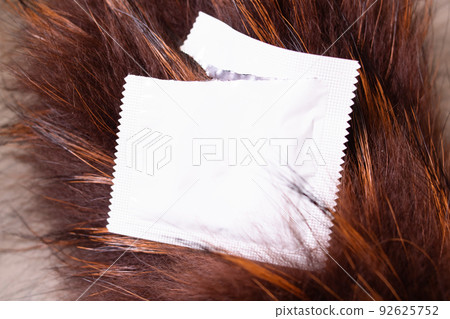 Condom packaging on a red background closeup Condom packaging on a red background closeup 92625752