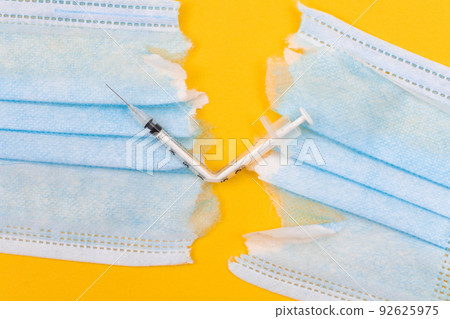 Broken Medical Syringe and Torn Medical Face Mask Broken Medical Syringe and Torn Medical Face Mask 92625975