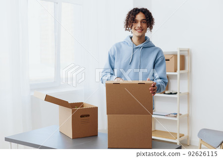 A young man cardboard boxes in the room unpacking interior 92626115