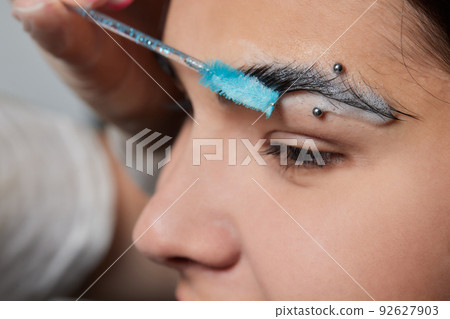 Beautiful young girl got correction of eyebrows in a beauty salon. Beautiful young girl got correction of eyebrows in a beauty salon. 92627903