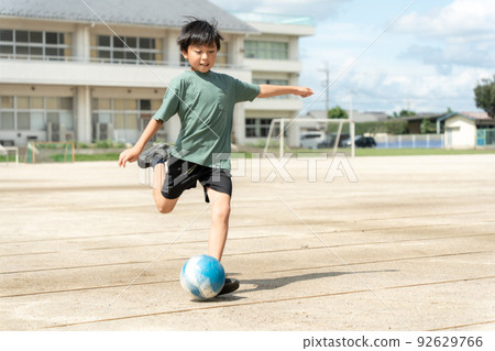 小學男孩在學校踢足球 92629766