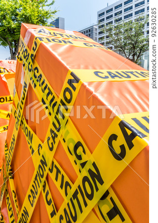 An object wrapped with CAUTION letter tape seen in the city An object wrapped with CAUTION letter tape seen in the city 92630285
