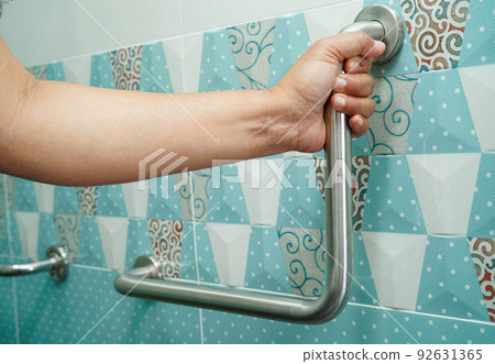 Asian woman patient use toilet support rail in bathroom, handrail safety grab bar, security in nursing hospital. Asian woman patient use toilet support rail in bathroom, handrail safety grab bar, security in nursing hospital. 92631365