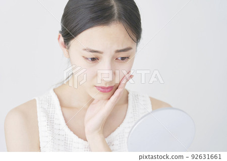 一個女人擔心照鏡子白色背景 92631661