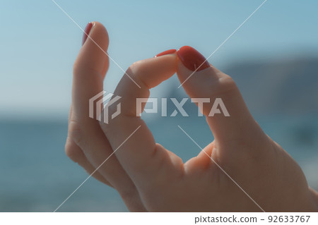 Young woman with long hair, fitness instructor in Sportswear Leggings and Tops, stretching before pilates, on a yoga mat near the sea on a sunny day, female fitness yoga routine concept 92633767