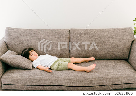 Japanese boy taking a nap on the sofa at home Japanese boy taking a nap on the sofa at home 92633969