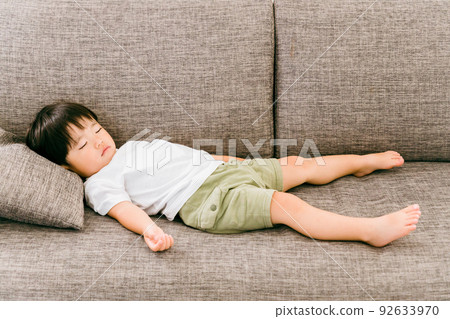 Japanese boy taking a nap on the sofa at home Japanese boy taking a nap on the sofa at home 92633970