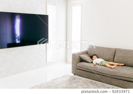 Japanese boy taking a nap on the sofa at home Japanese boy taking a nap on the sofa at home 92633971