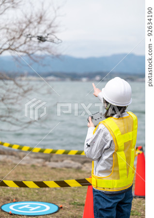 在建築工地操作無人機並拍照的年輕女工 92634190