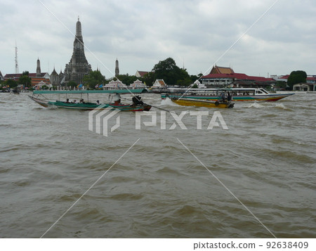 Ferry boats and excursion boats crossing the murky Chao Phraya River Ferry boats and excursion boats crossing the murky Chao Phraya River 92638409