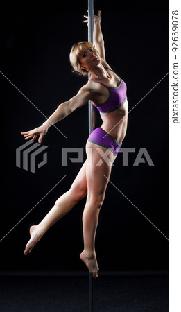 The strong and graceful young girl performing acrobatic exercises on pylon The strong and graceful young girl performing acrobatic exercises on pylon 92639078