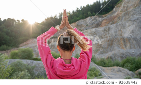 Young woman practicing mindfulness with her palms joined above her head Young woman practicing mindfulness with her palms joined above her head 92639442