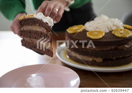 Serving chocolate orange cake on a plate Serving chocolate orange cake on a plate 92639447