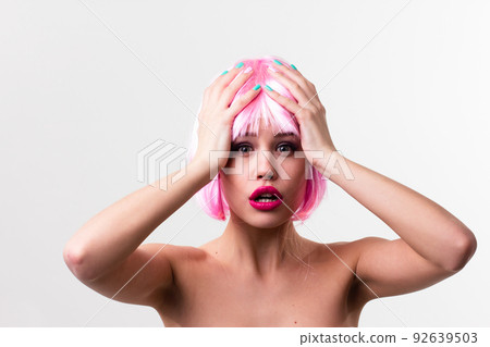 Face of a young woman with bright makeup on a pink background with gathered hair in a smooth ponytail. Face of a young woman with bright makeup on a pink background with gathered hair in a smooth ponytail. 92639503