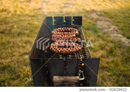 Delicious sausage on grill with spices and herbs on the flaming grill. Selective focus. Delicious sausage on grill with spices and herbs on the flaming grill. Selective focus. 92639632