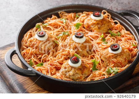 halloween Spaghetti with tomato sauce and meatballs with eyes in a pan on the table close-up. Horizontal 92640179