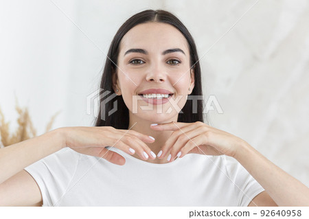 Young beautiful woman smiling and looking at the camera, close-up photo, morning portrait at home. 92640958
