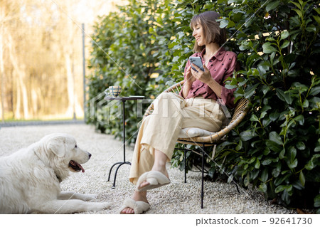 Happy woman with her dog at backyard Happy woman with her dog at backyard 92641730