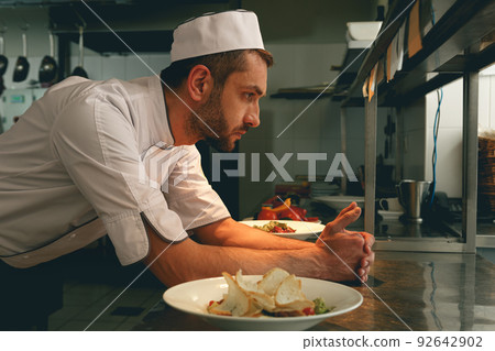 Tired chef on kitchen restaurant waiting for a new order 92642902