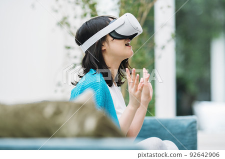 Woman enjoying VR in her living room 92642906