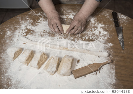 Hands kneading dough for gnocchi. Hands kneading dough for gnocchi. 92644188