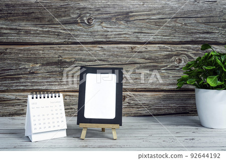 White September 2022 calendar on wooden desk with paper frame and potted plant. 2022 new year concept. Copy space. White September 2022 calendar on wooden desk with paper frame and potted plant. 2022 new year concept. Copy space. 92644192