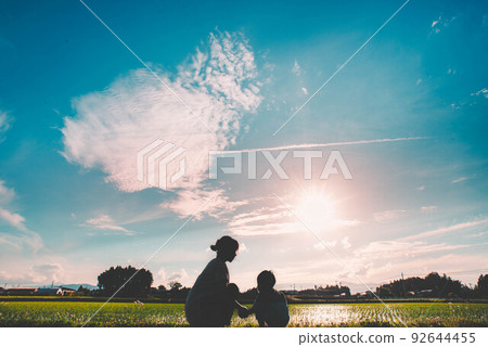 Family time where mothers and children spend time under the beautiful evening sky 92644455