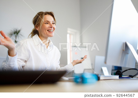 Friendly business woman talking on video call in the office 92644567