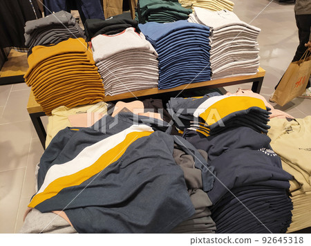 SELANGOR, MALAYSIA -APRIL 4, 2022: Various types of clothes are being sold in the store. Displayed by hanging and folding. Have a price tag for buyer review. Separated by type and brand SELANGOR, MALAYSIA -APRIL 4, 2022: Various types of clothes are being sold in the store. Displayed by hanging and folding. Have a price tag for buyer review. Separated by type and brand 92645318