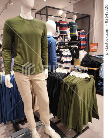 SELANGOR, MALAYSIA -APRIL 4, 2022: Various types of clothes are being sold in the store. Displayed by hanging and folding. Have a price tag for buyer review. Separated by type and brand SELANGOR, MALAYSIA -APRIL 4, 2022: Various types of clothes are being sold in the store. Displayed by hanging and folding. Have a price tag for buyer review. Separated by type and brand 92645320